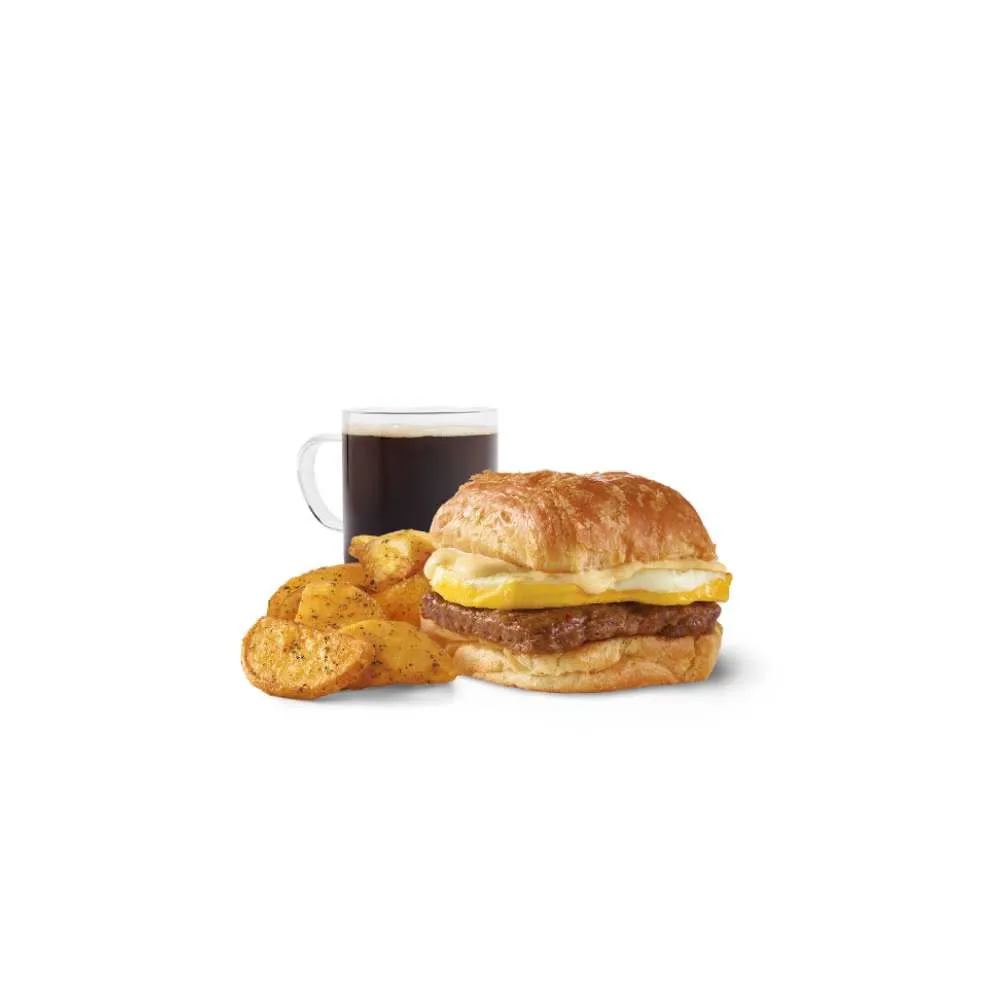 Wendy's sausage egg croissant breakfast combo with crispy seasoned potatoes and black coffee